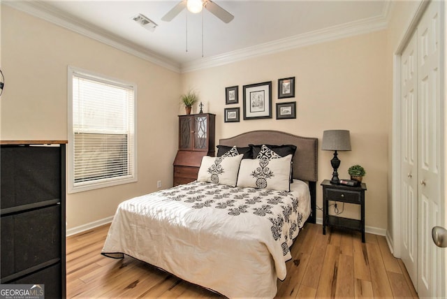 bedroom with light hardwood / wood-style flooring, ornamental molding, a closet, and ceiling fan