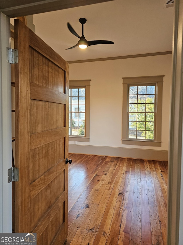 spare room featuring ceiling fan, ornamental molding, and light hardwood / wood-style flooring