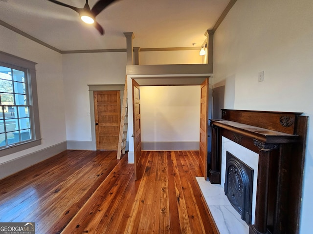 213 W Hightower Trl, Social Circle, GA 30025 - unfurnished living room with hardwood / wood-style flooring, ceiling fan, ornamental molding, a fireplace with flush hearth, and baseboards