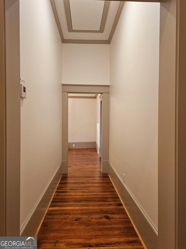 corridor featuring dark wood-type flooring and ornamental molding