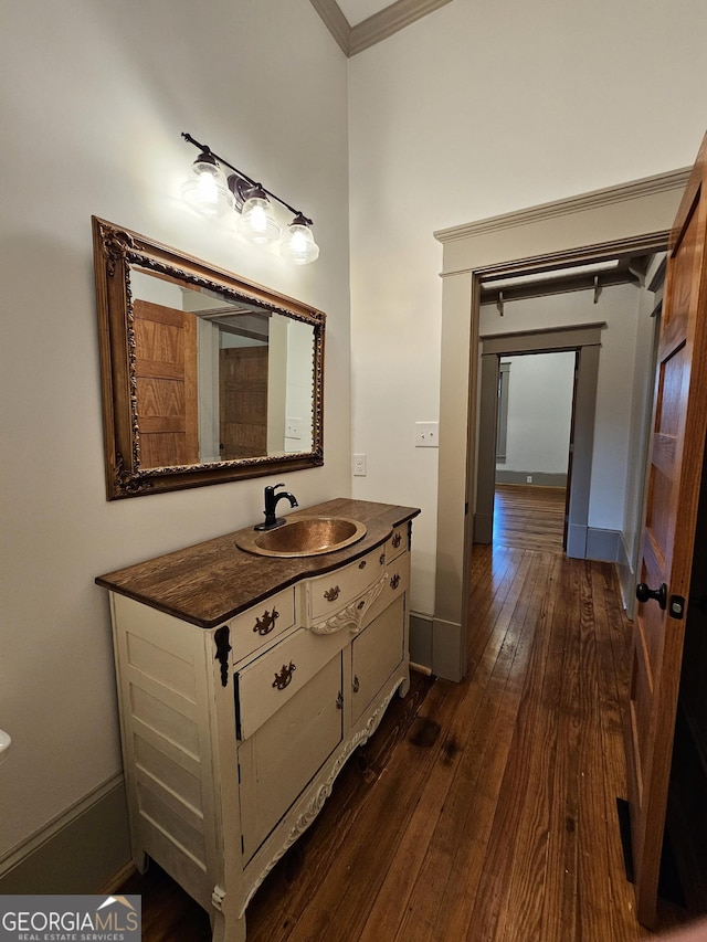 bathroom with ornamental molding, wood-type flooring, and vanity