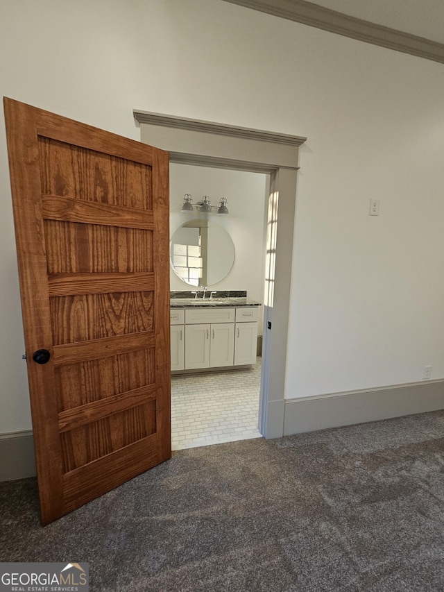 interior space with crown molding, sink, and carpet floors