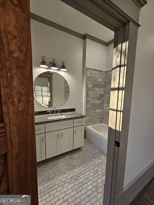 bathroom with ornamental molding, vanity, and a tub