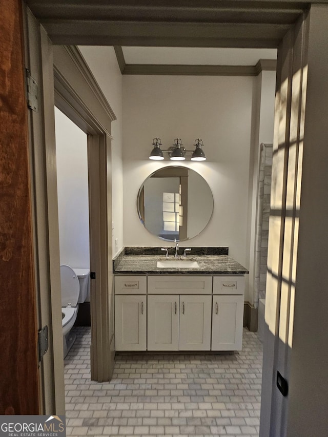 bathroom featuring vanity, crown molding, and toilet