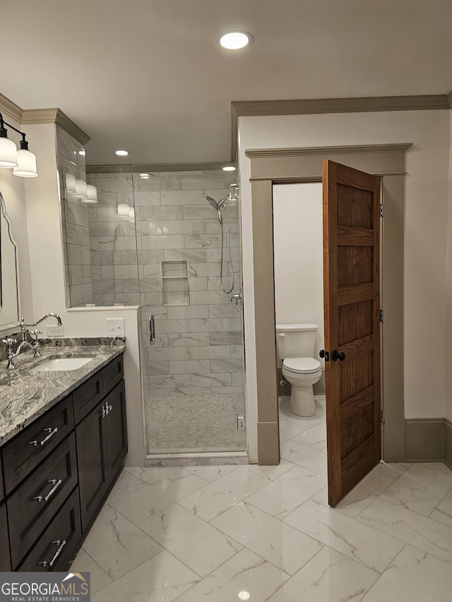 bathroom featuring vanity, crown molding, a shower with door, and toilet