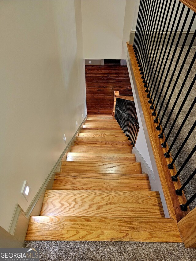 213 W Hightower Trl, Social Circle, GA 30025 - stairs featuring wood finished floors and baseboards