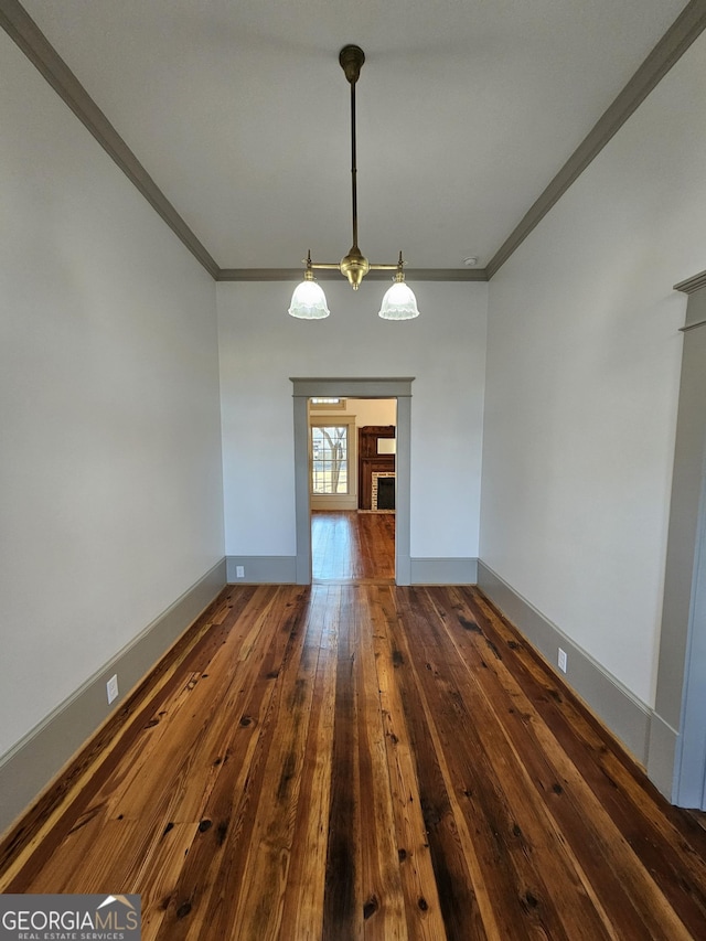 unfurnished dining area featuring crown molding and dark wood-type flooring