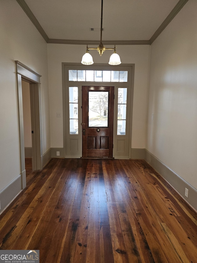 foyer entrance with ornamental molding and dark wood-type flooring