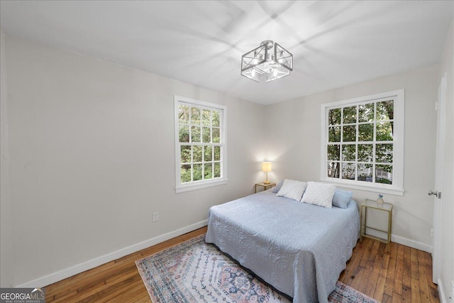 bedroom with dark hardwood / wood-style floors