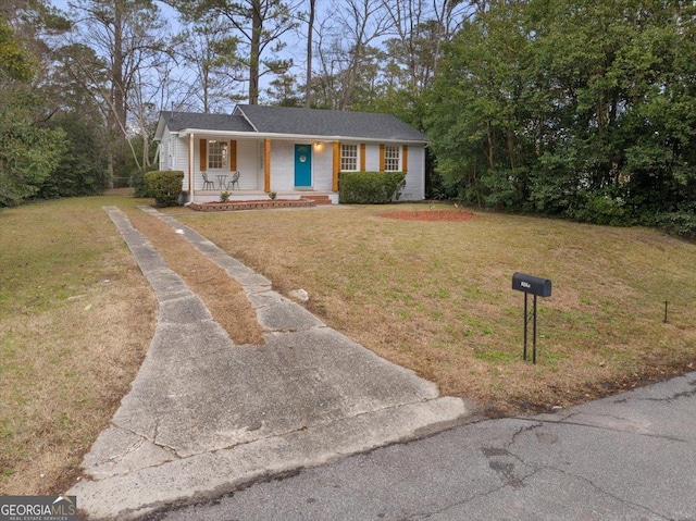 ranch-style house featuring a porch and a front yard