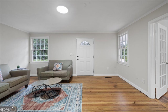 living room featuring ornamental molding and light hardwood / wood-style flooring