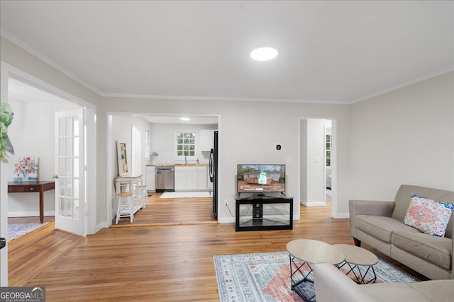 living room with crown molding and light wood-type flooring