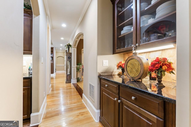 hallway featuring crown molding and light hardwood / wood-style floors