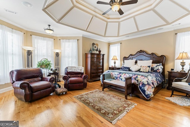 bedroom with multiple windows, hardwood / wood-style floors, ornamental molding, and ceiling fan