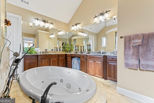 bathroom featuring vaulted ceiling, a relaxing tiled tub, and vanity