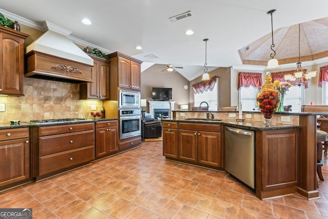 kitchen featuring pendant lighting, sink, stainless steel appliances, tasteful backsplash, and custom exhaust hood