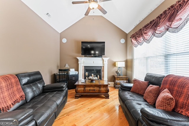 living room featuring lofted ceiling, light hardwood / wood-style floors, and ceiling fan