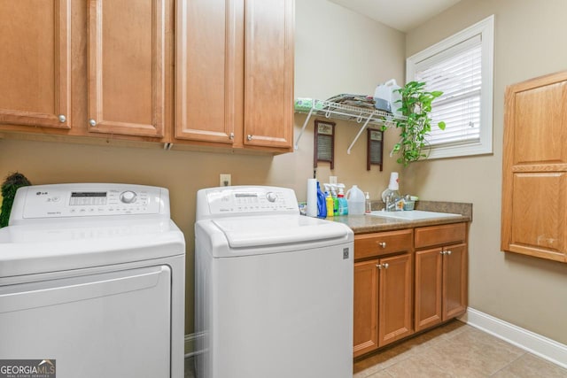 laundry room featuring cabinets, light tile patterned flooring, sink, and independent washer and dryer