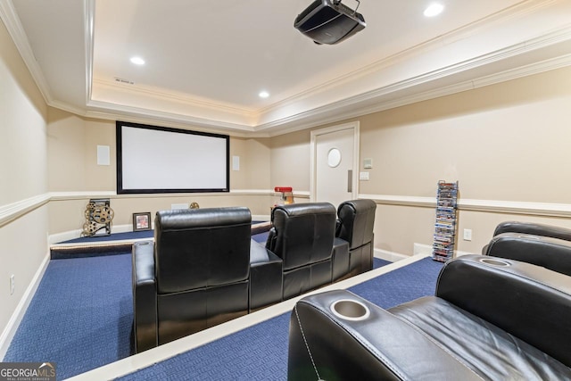 home theater room with a raised ceiling, ornamental molding, and carpet floors