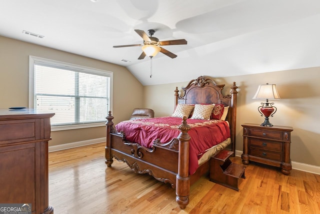 bedroom with ceiling fan, lofted ceiling, and light hardwood / wood-style floors