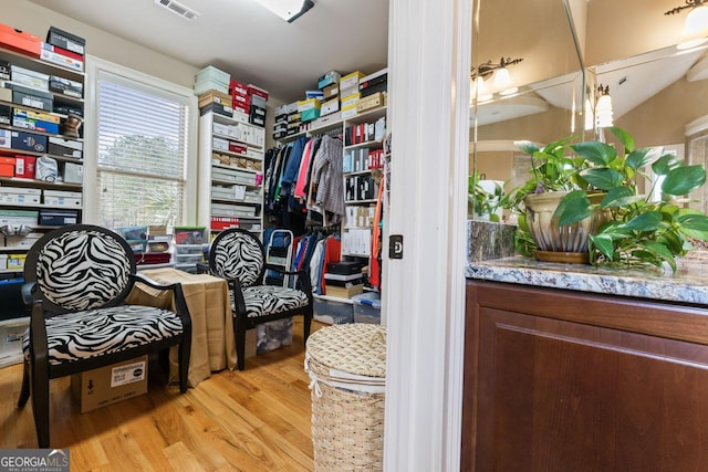 walk in closet with light hardwood / wood-style floors