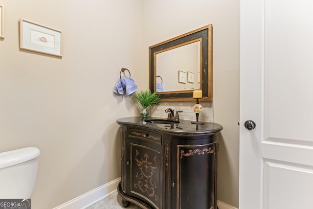 bathroom with vanity, tasteful backsplash, and toilet