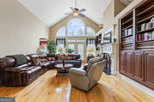 living room with ceiling fan, high vaulted ceiling, and light hardwood / wood-style floors