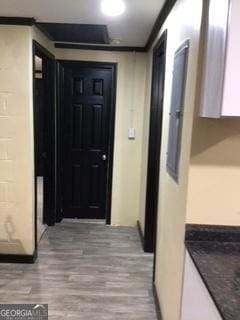 hallway featuring ornamental molding and light hardwood / wood-style flooring