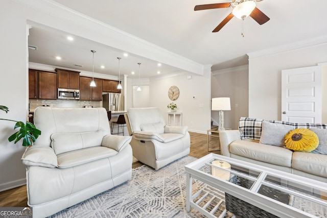 living room with ornamental molding, ceiling fan, and light wood-type flooring