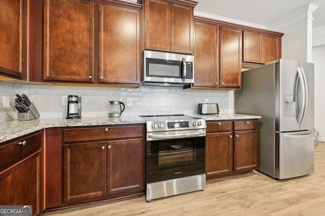 kitchen featuring crown molding, appliances with stainless steel finishes, tasteful backsplash, and light hardwood / wood-style flooring