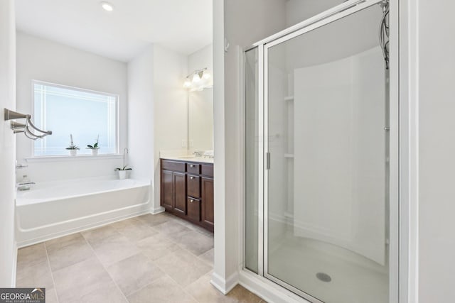 bathroom featuring tile patterned flooring, shower with separate bathtub, and vanity