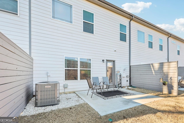 back of property with central AC unit and a patio