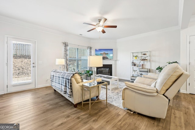 living room featuring crown molding, a healthy amount of sunlight, hardwood / wood-style floors, and ceiling fan