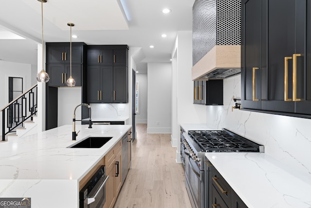 kitchen with custom exhaust hood, light stone countertops, appliances with stainless steel finishes, and sink