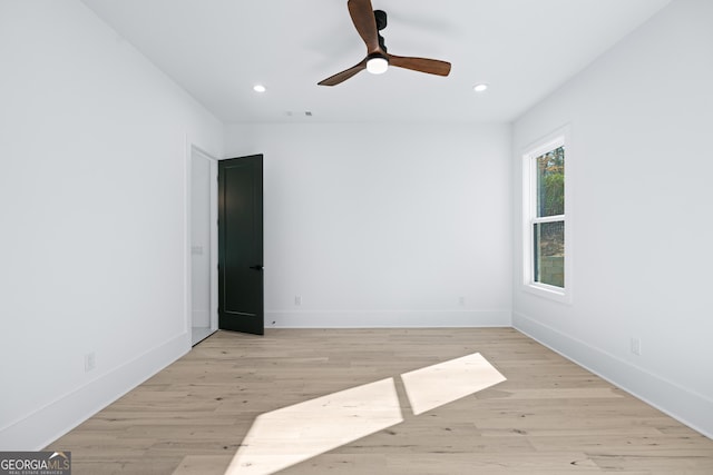 empty room with ceiling fan and light hardwood / wood-style floors