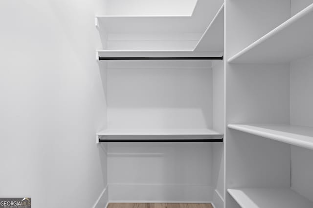 spacious closet featuring light hardwood / wood-style floors