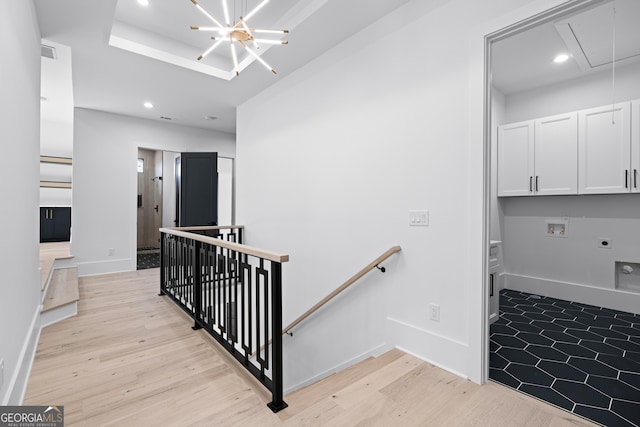 stairway featuring hardwood / wood-style flooring and a chandelier