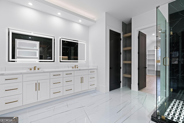 bathroom featuring a shower with door and vanity