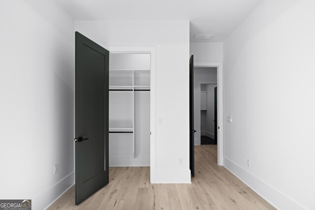 unfurnished bedroom with a closet and light hardwood / wood-style flooring