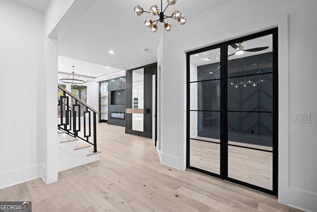 entryway featuring an inviting chandelier and light hardwood / wood-style flooring