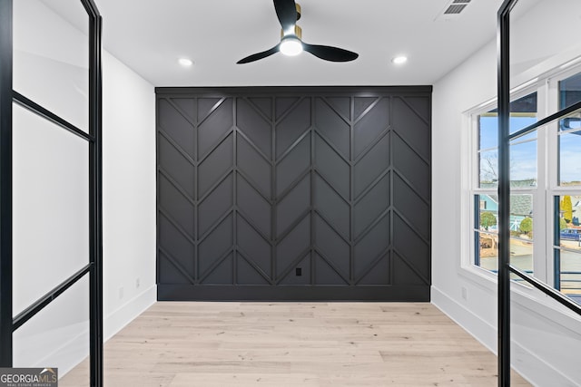 empty room with ceiling fan and light wood-type flooring