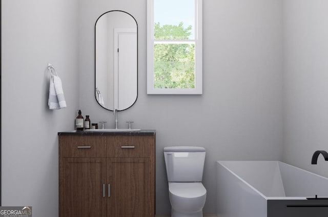 bathroom with vanity, a bathing tub, and toilet