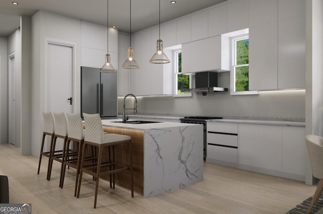 kitchen featuring a kitchen island with sink, light stone counters, stainless steel appliances, and white cabinets