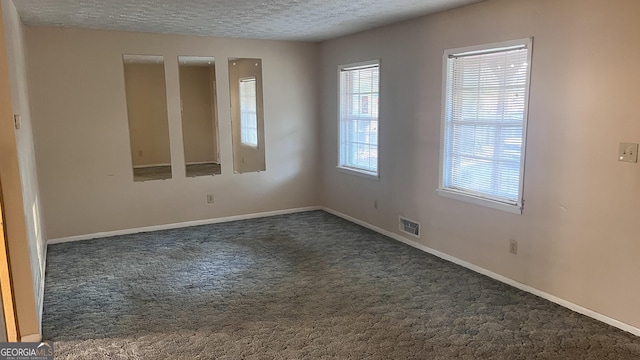 carpeted spare room with a textured ceiling