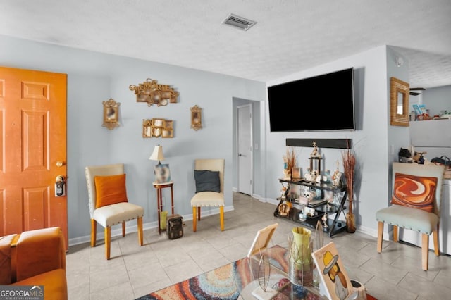 living room with light tile patterned flooring and a textured ceiling