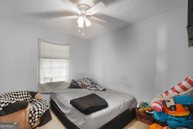 carpeted bedroom featuring a textured ceiling and ceiling fan