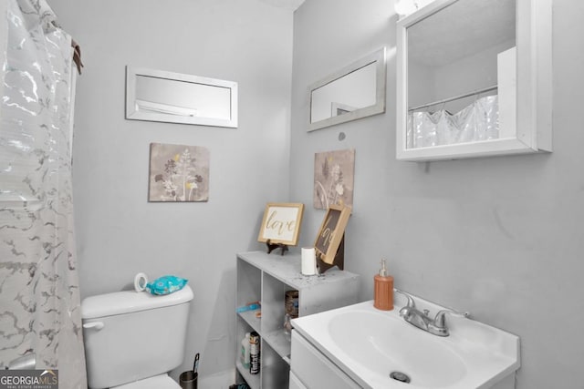 bathroom with walk in shower, vanity, and toilet