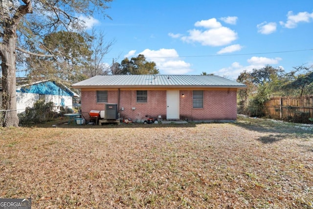 back of house with a lawn and central air condition unit