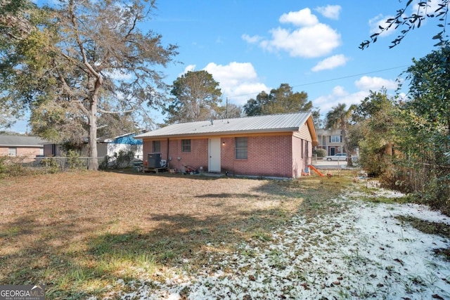 rear view of house featuring cooling unit and a yard