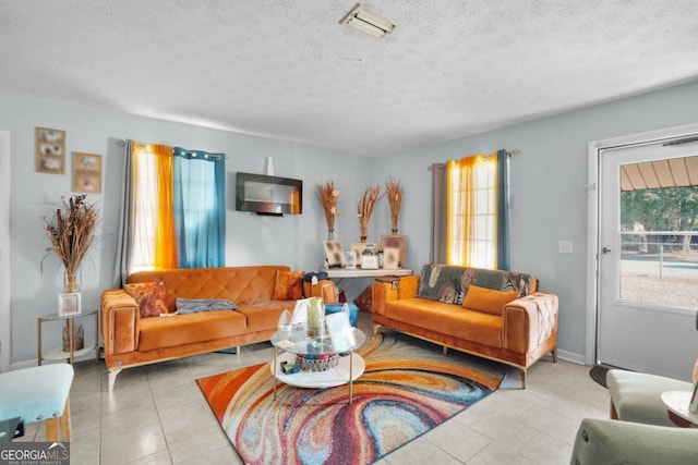 tiled living room featuring a textured ceiling